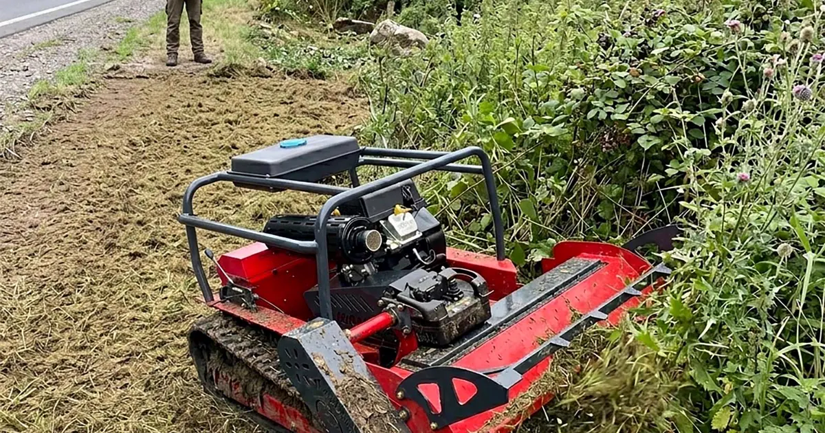 Operator using a remote-controlled tracked mower for roadside bank vegetation control